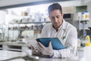 Male chemist reading medical data in laboratory.